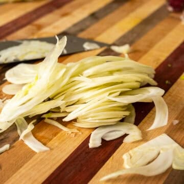 Shaved fennel on a cutting board.