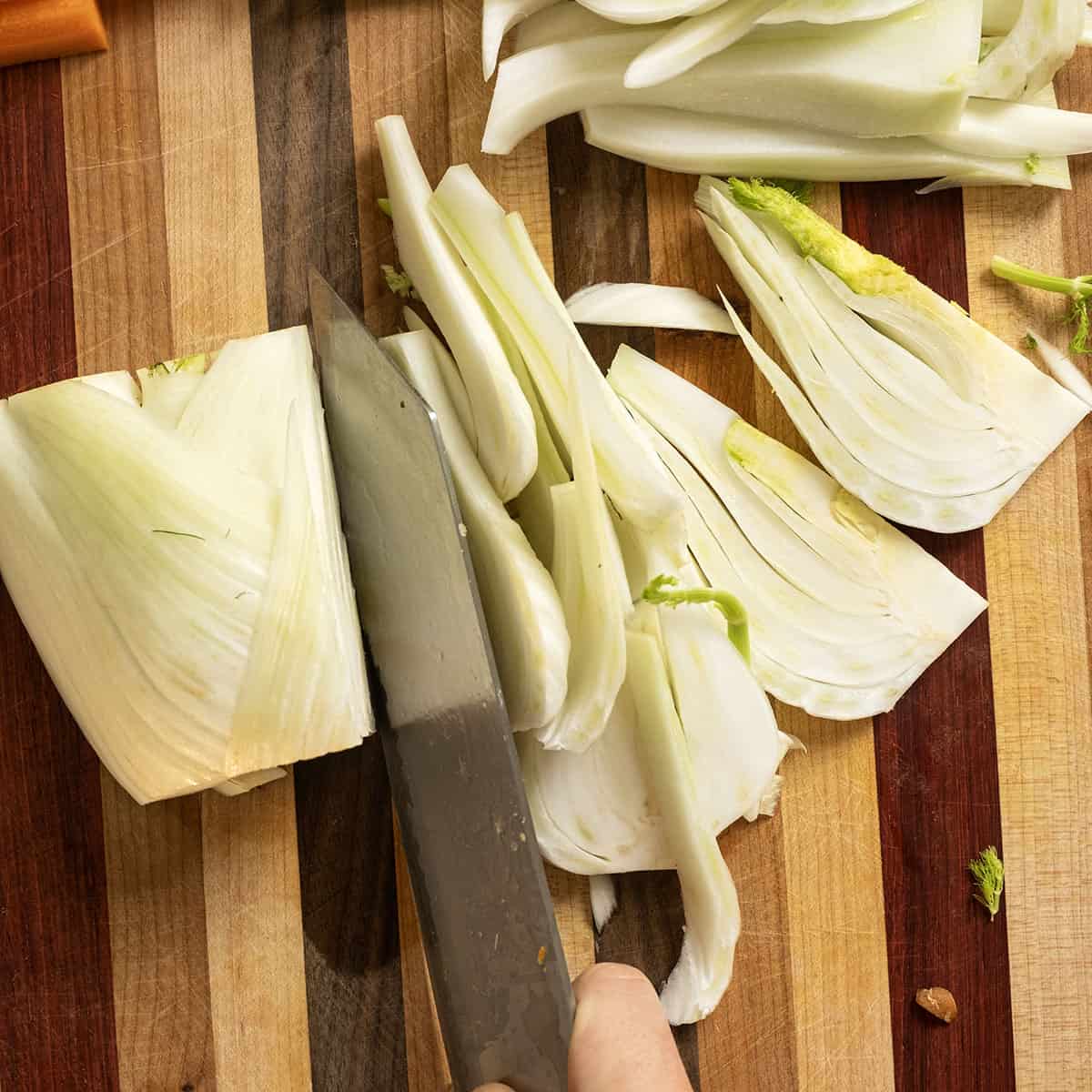 Slice fennel on a cutting baord.