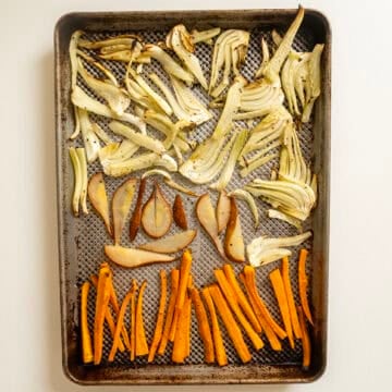 Roasted fennel, carrots, and pears on a baking pan.