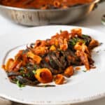Squid ink pasta with calamari on a plate.