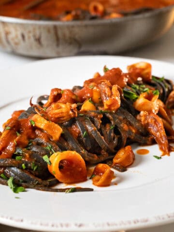 Squid ink pasta with calamari on a plate.