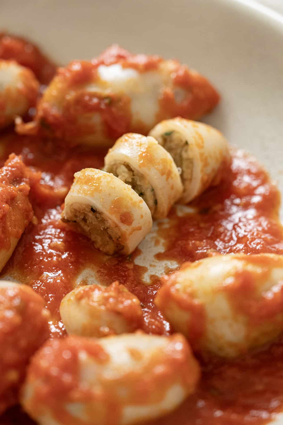 Sliced open stuffed calamari on a plate.