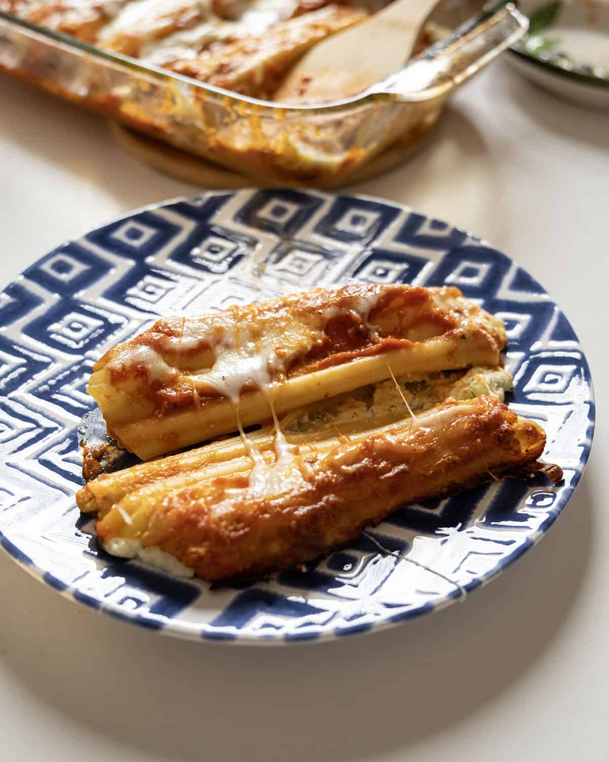 Baked manicotti topped with smooth marinara and mozzarella.