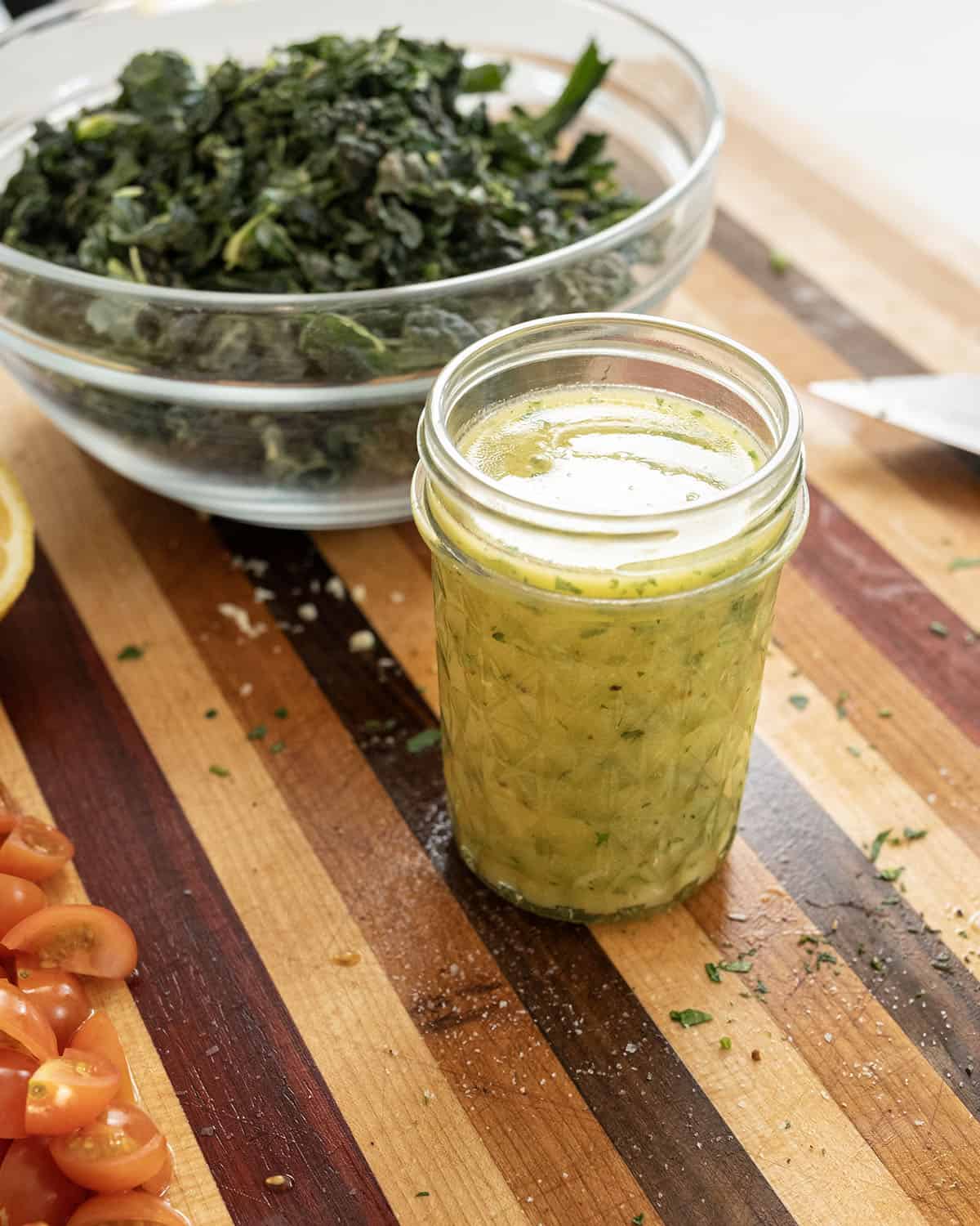 Dressing in a mason jar next to a salad.