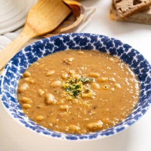 Fennel and white bean soup in a bowl topped with parsley and lemon zest.