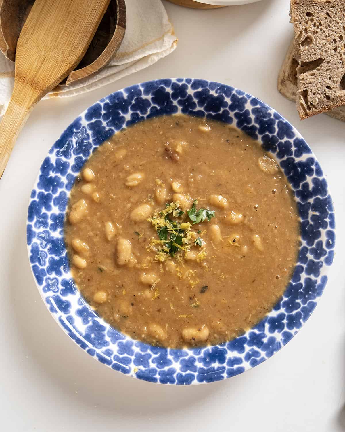 Fennel and white bean soup in a bowl topped with parsley and lemon zest.