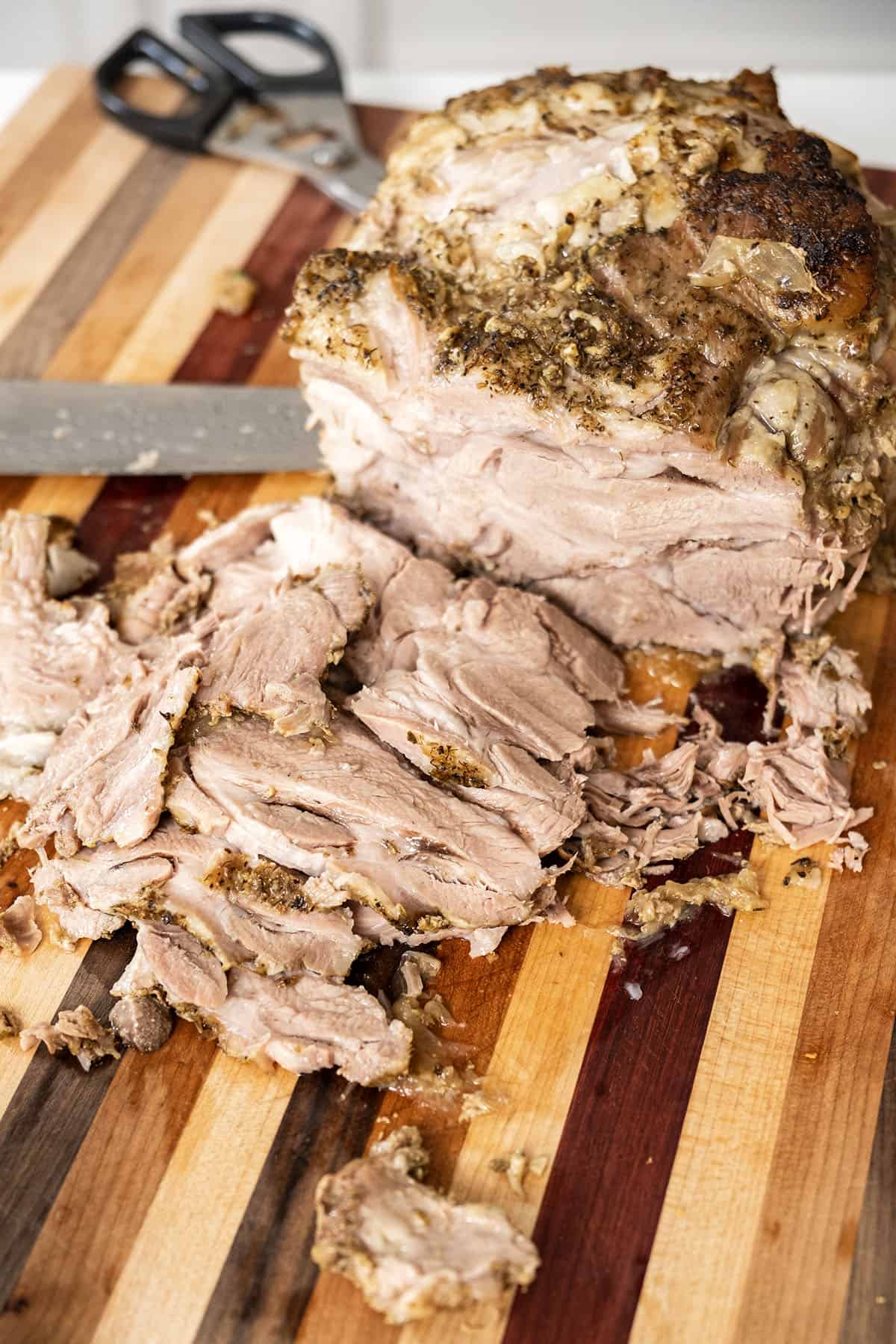 Sliced pork shoulder on a cutting board.