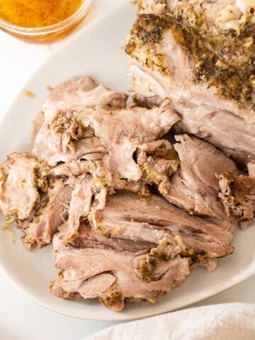 Sliced pork shoulder on a cutting board.