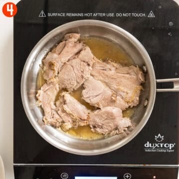 Heating sliced pork shoulder in a pan with pork au jus.