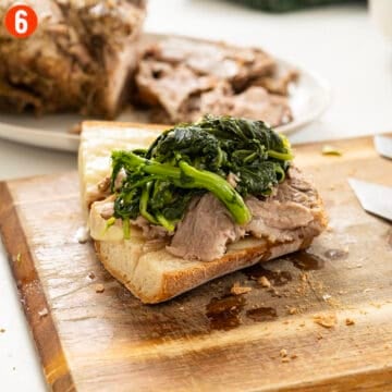 Topping Italian bread and provolone with pork shoulder and broccoli rabe.