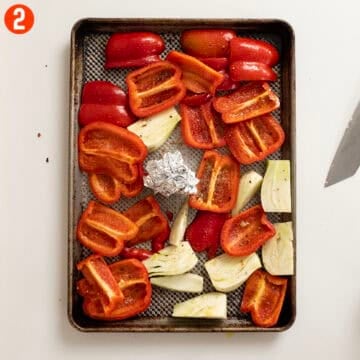 Red peppers, fennel, and garlic on a sheet pan with olive oil, salt, and pepper.