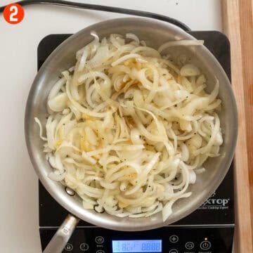 Translucent sauteed onions in a saucepan.