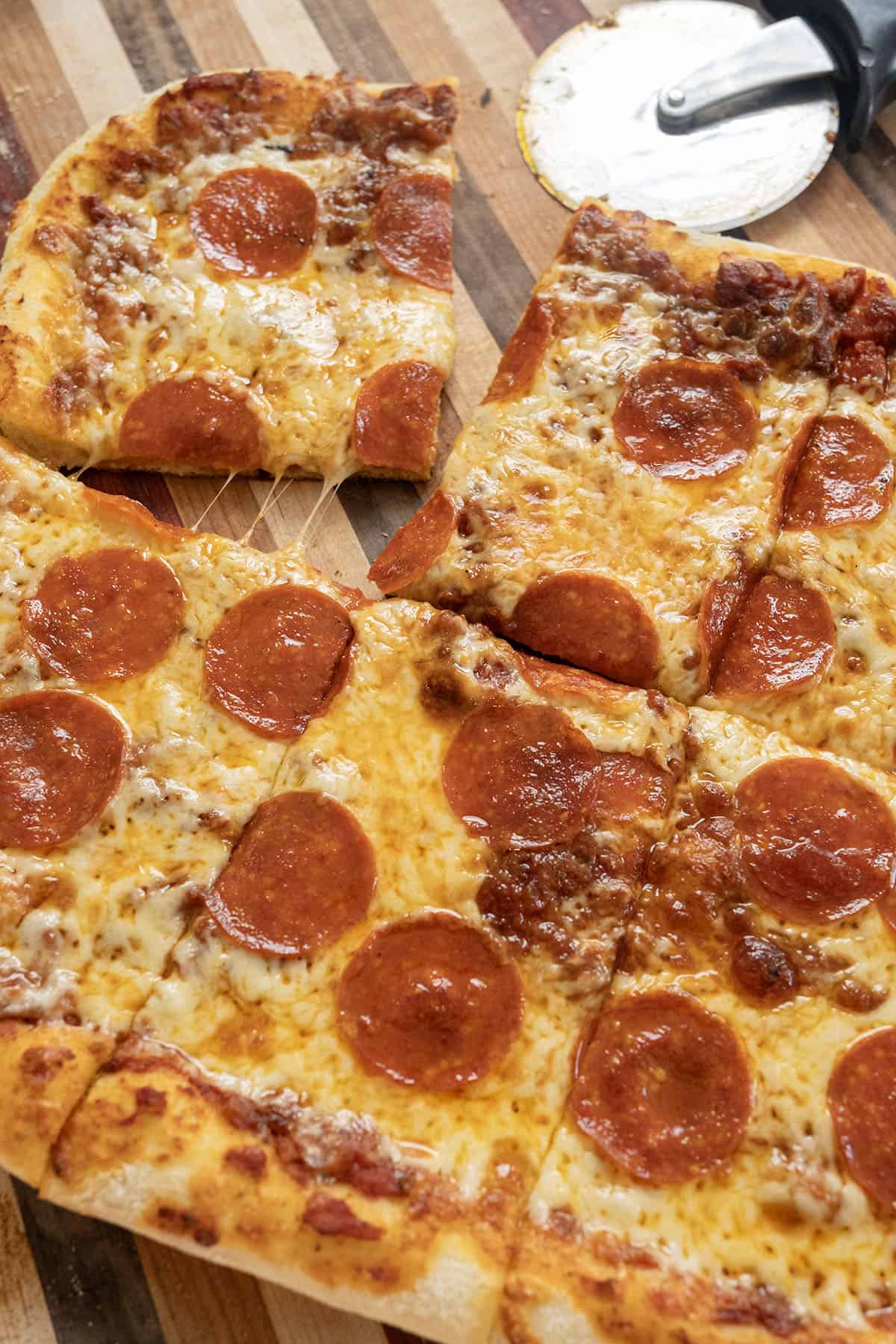 NY Style Pizza with pepperoni, cut on a cutting board.