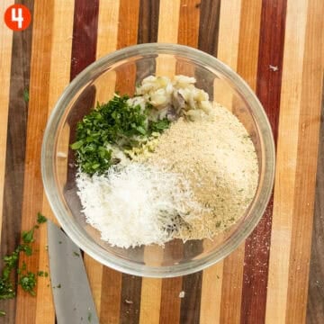 Boiled eggplant, parsley, garlic, breadcrumbs, parmigiana, salt and pepper in a bowl.