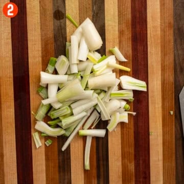 Chopped spring onions on a cutting board.