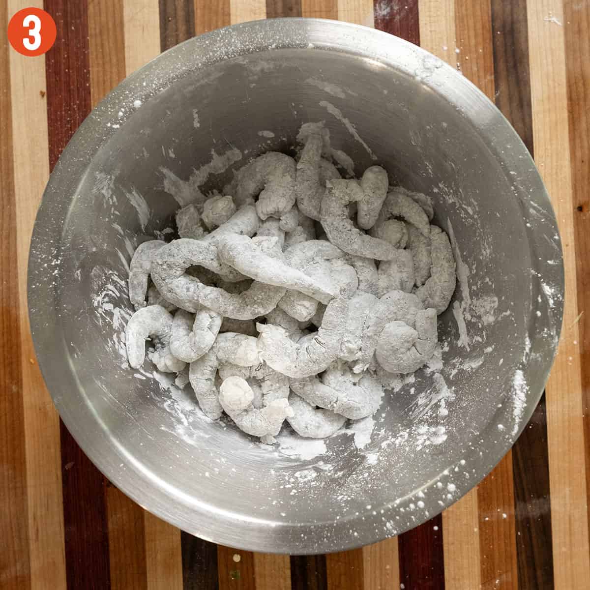 Tossing shrimp in cornstarch.
