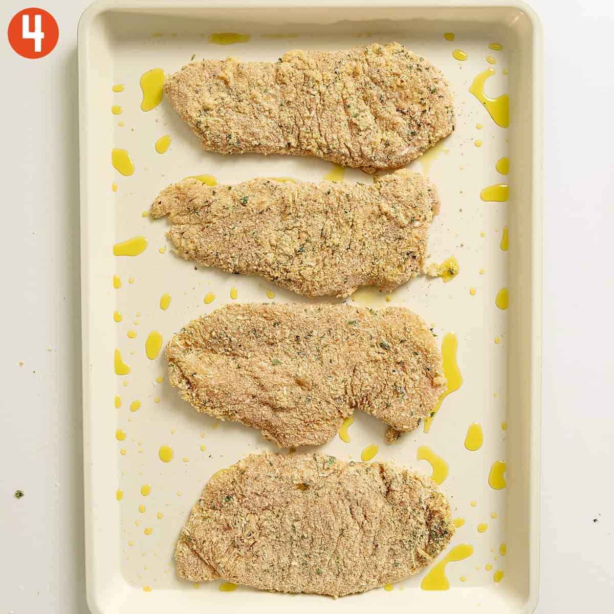 Chicken cutlets on a tray.
