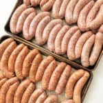 Homemade sausage on baking trays.