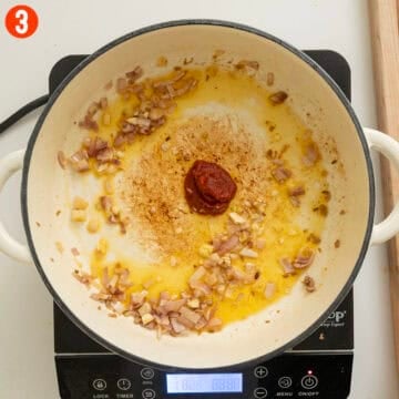 Sauteing garlic and tomato paste with shallots.