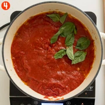 Simmering crushed tomatoes, basil and salt.
