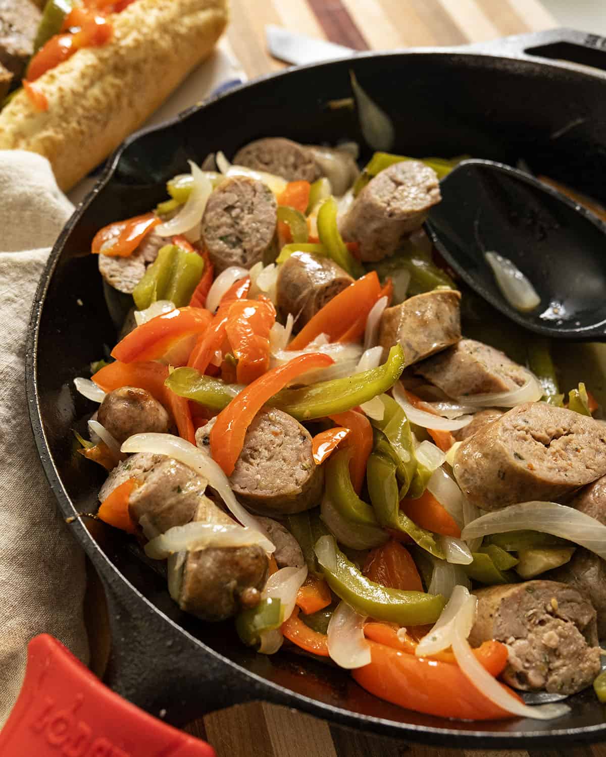 Grilled sausage and peppers in a cast iron pan.