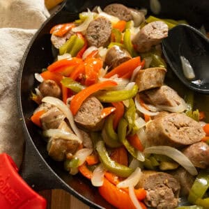 Grilled sausage and peppers in a cast iron pan.