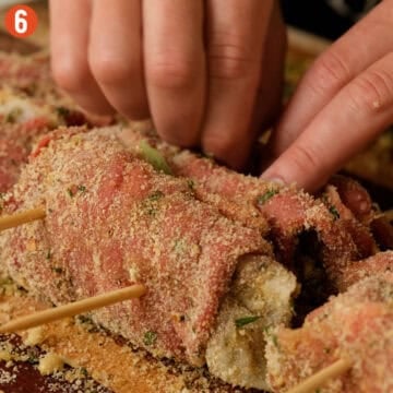 Skewering beef spiedini and placing bay leaves between each roll.