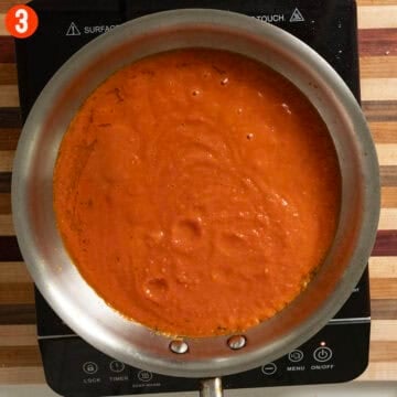 Simmering marinara sauce in a pan.