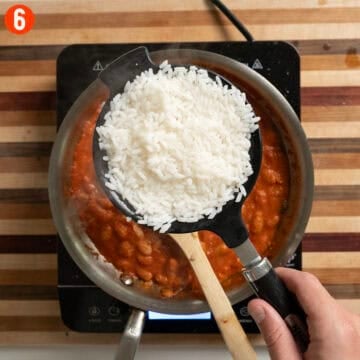 Boiled rice drained in a mesh strainer.