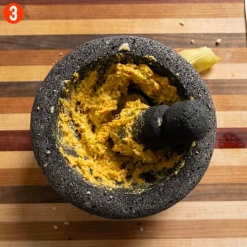 Grinding zucchini flowers into the nuts.