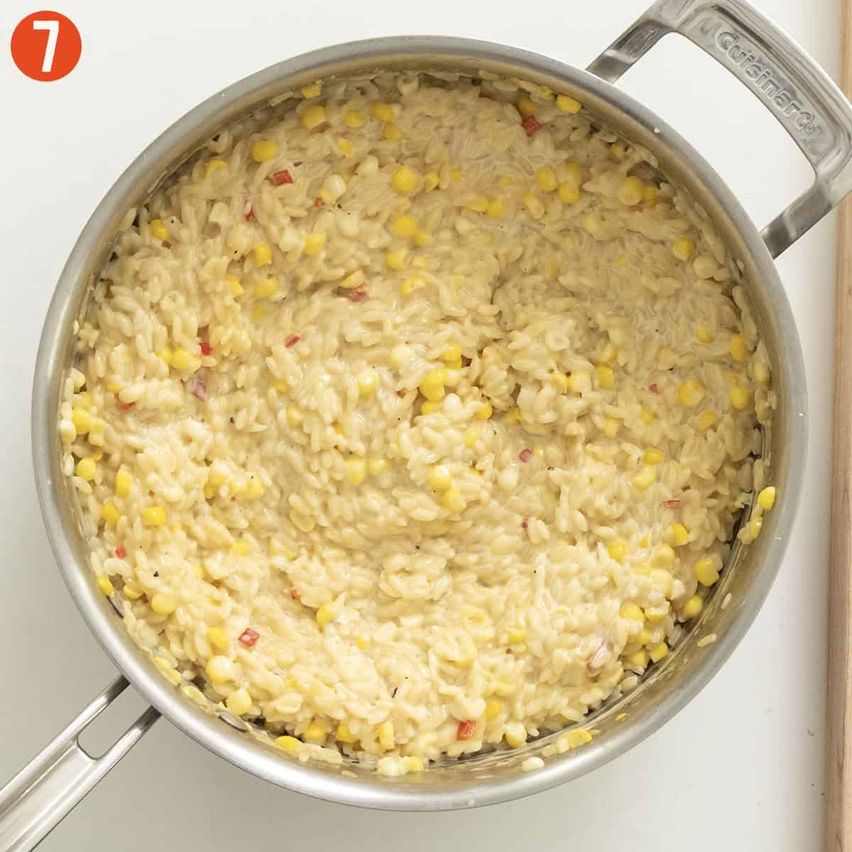 Corn orzo combined with heavy cream and parmigiano in a saucepan.
