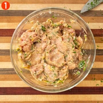 Mixing ingredients for chicken meatballs in a bowl.
