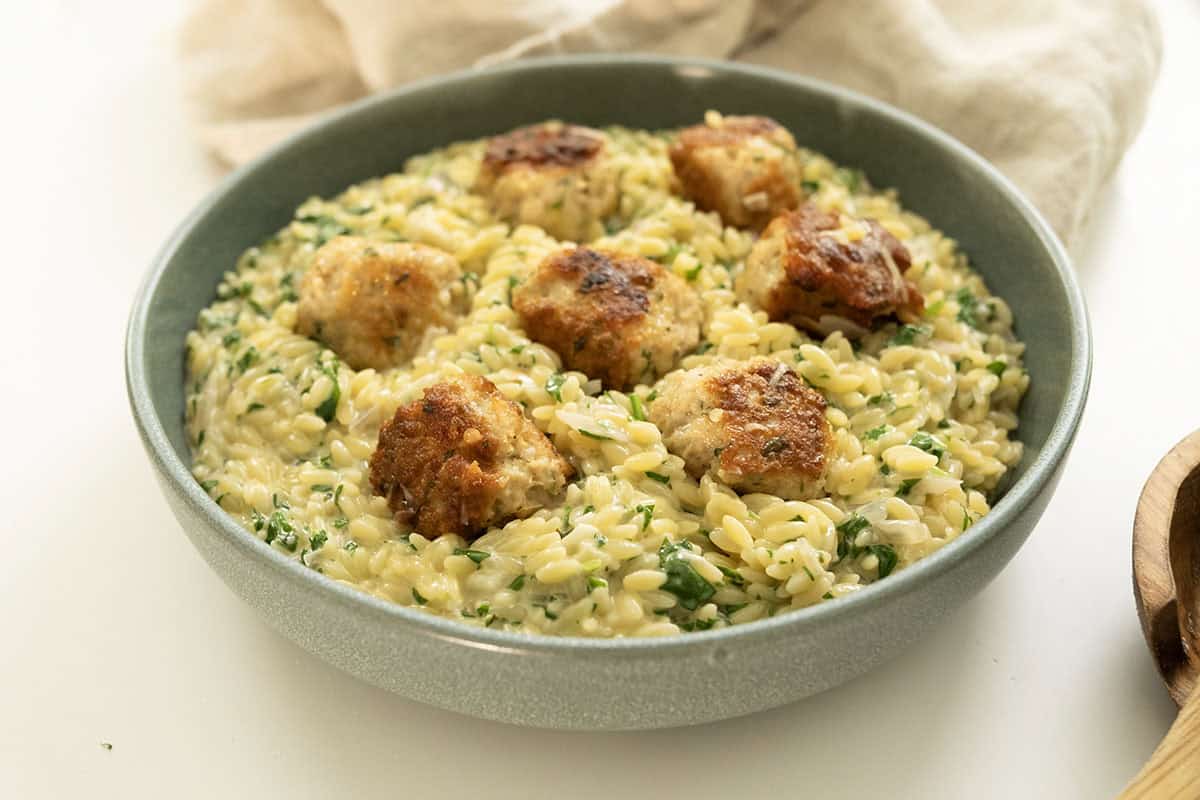 Finished Italian style meatballs in lemon spinach orzo.