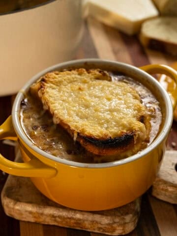 Licurdia soup in a bowl topped with bread and melted cheese.