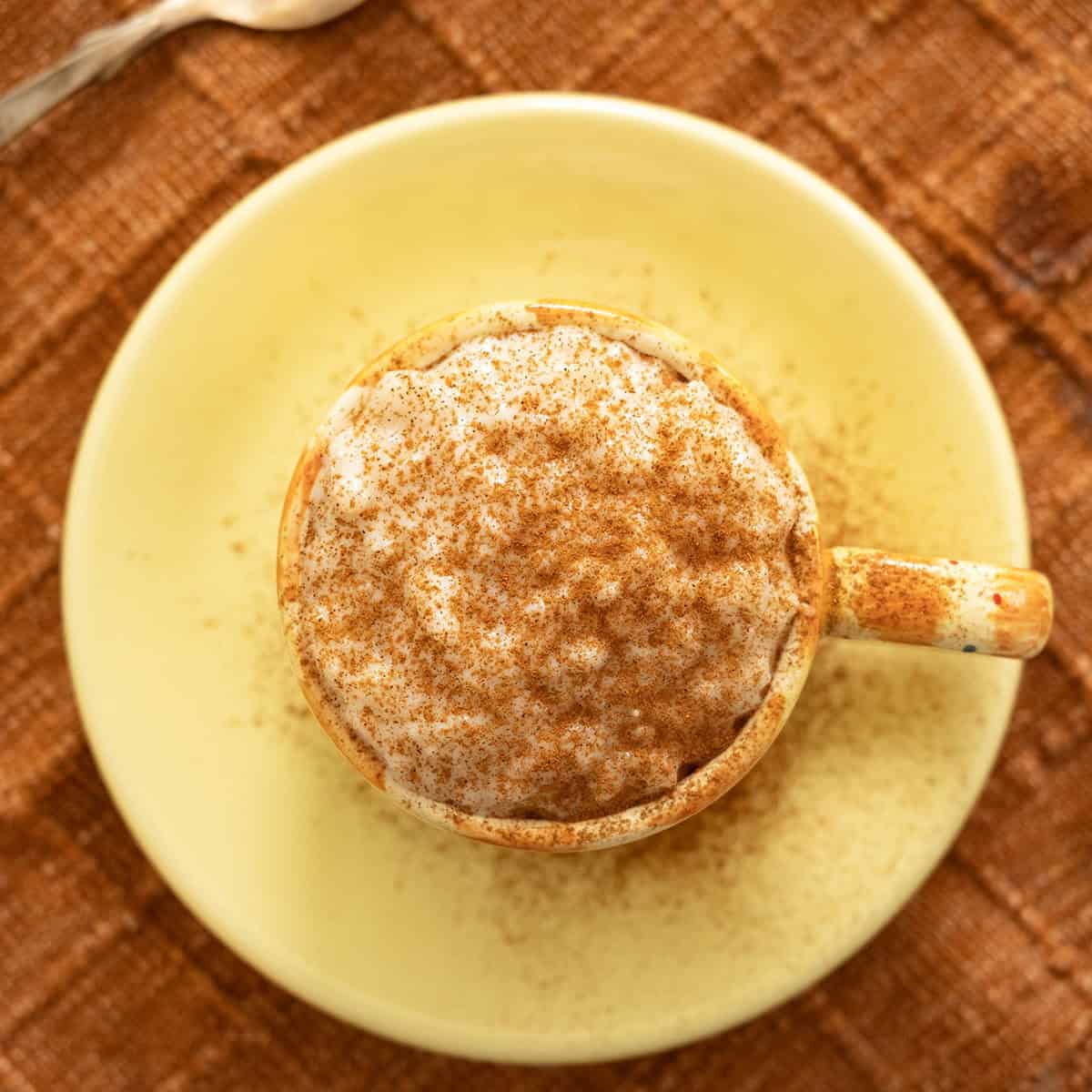 Italian rice pudding served in a cup, sprinkled with cinnamon.