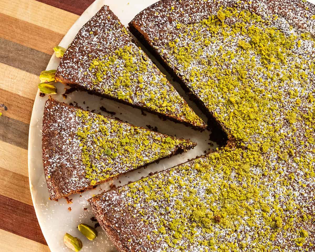 Italian Torta caprese topped with ground pistachios and powdered sugar.