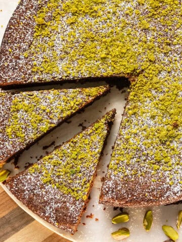 Italian Torta caprese topped with ground pistachios and powdered sugar.