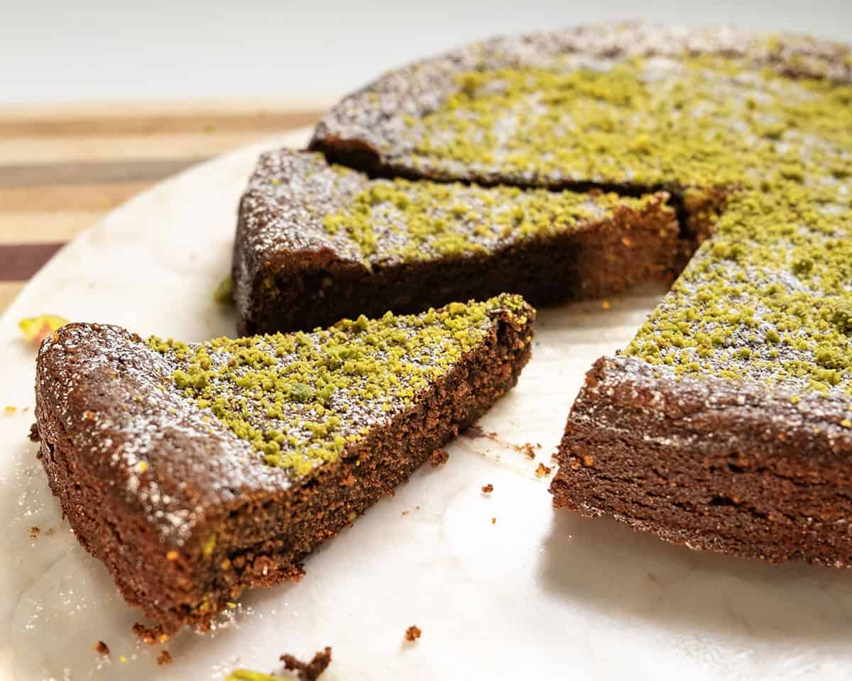 Italian Torta caprese topped with ground pistachios and powdered sugar.