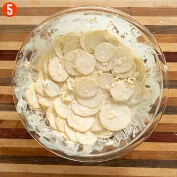 Combining potatoes, cheese, and heavy cream in a large bowl.