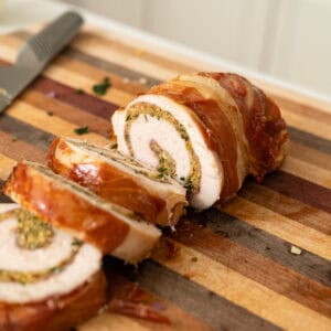Rolled stuffed turkey breast sliced on a cutting board.