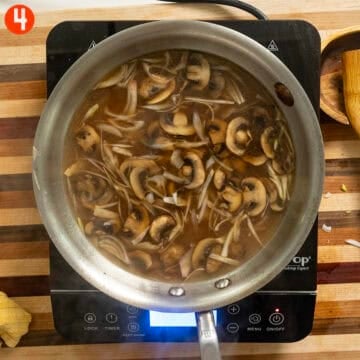 Simmering mushrooms and shallots in stock and marsala wine.