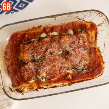 Baked, unbreaded, eggplant rollatini in a tray.