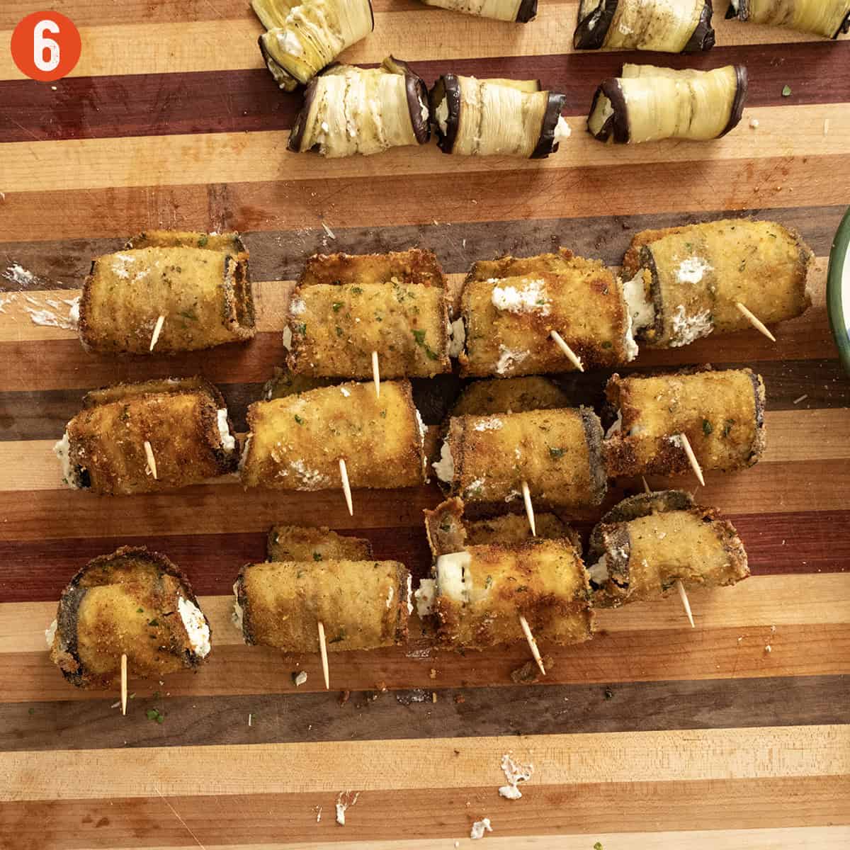 Fried eggplant rolled with ricotta and stuck with a toothpick.