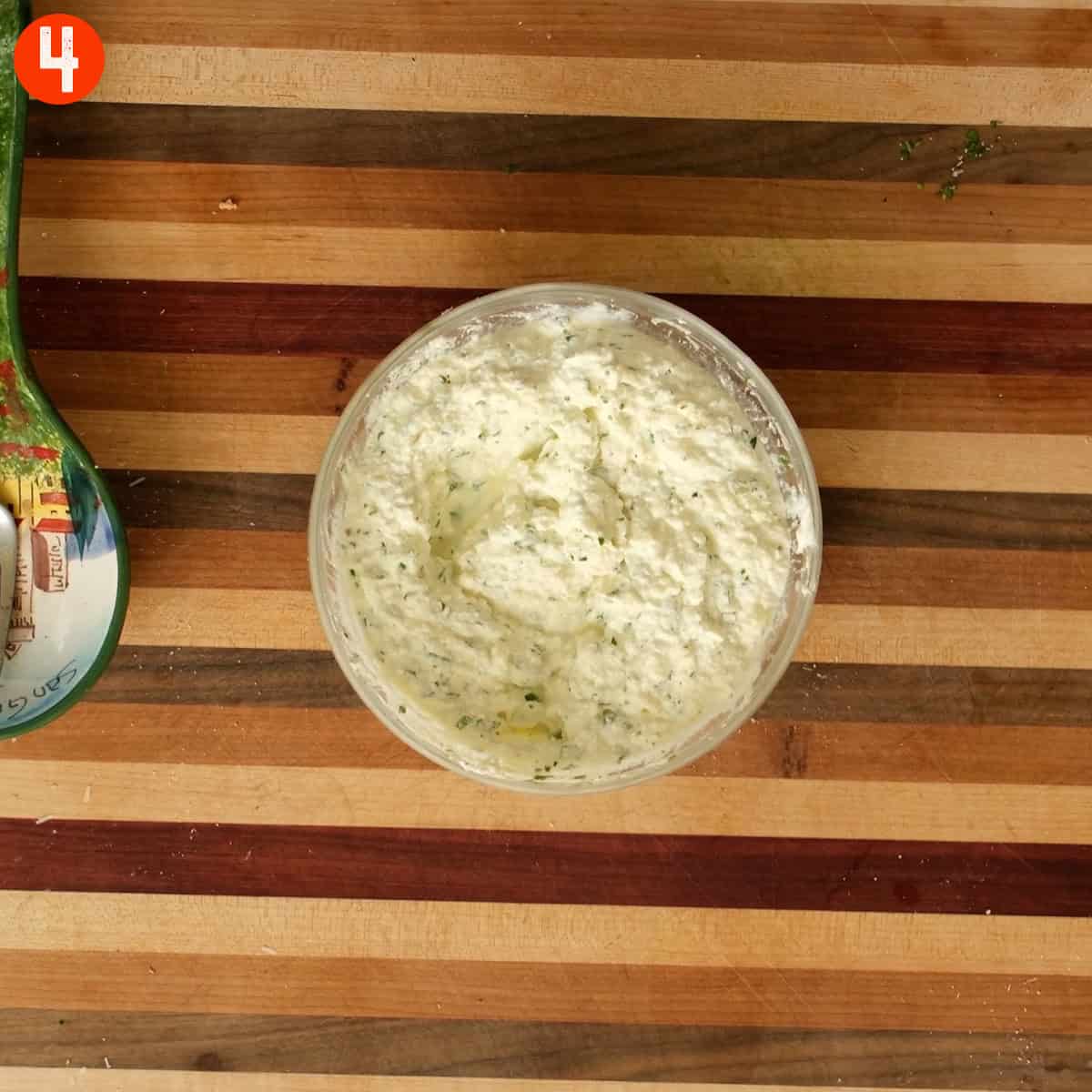 Ricotta and seasoning mixed together in a bowl.