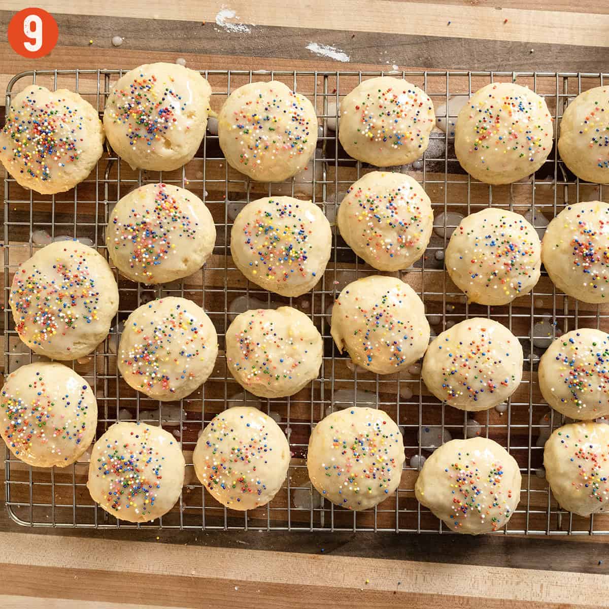 Cookies resting after being dipped in icing and topped with non-pareils.